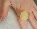 Off white resin flower ring on finger
