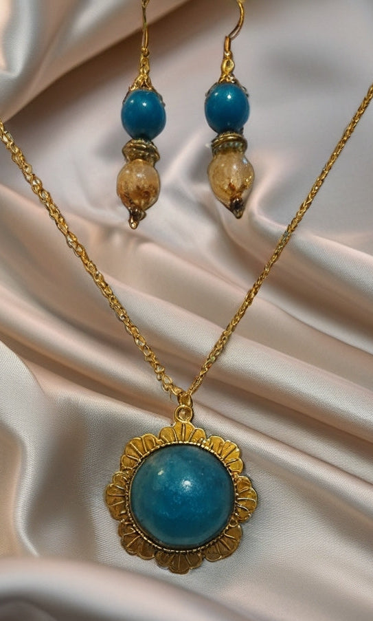 Gold necklace and earrings set with blue beads and blue pendant